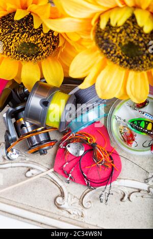 Pesca tackles, linee e mulinello con decorazione primaverile con girasoli e cuori rossi Foto Stock