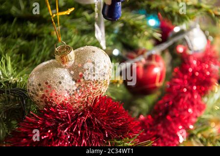 Forma di cuore ninnolo oro glitter albero di Natale ornamento, dettaglio, vicino. Foto Stock