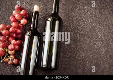 Bottiglie di vino rosso con grappolo di uva laici piatta Foto Stock