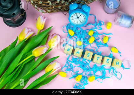 Parola Pasqua su cubetti di legno e circondato con molteplici decorazioni uovo come una festa di sfondo composizione pasquale. Foto Stock
