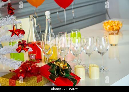 Qui sono le decorazioni dell'albero di Natale e molte scatole di regalo rosse luminose. Posto su un bel tavolo di legno per prepararsi a festeggiare le vacanze di Natale Foto Stock