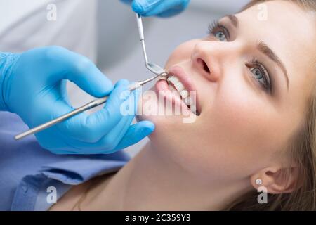 Dentista esaminando una denti del paziente al dentista. Foto Stock