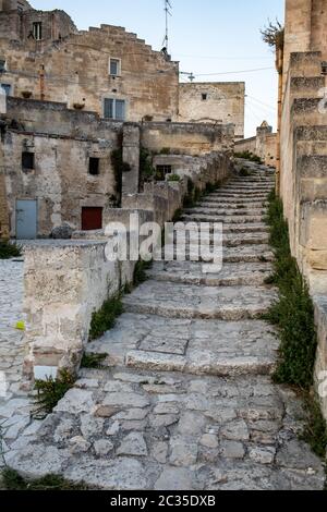 Matera, Italia - 15 settembre 2019: Tipiche scale acciottolate in un vicolo laterale della strada, nei Sassi di Matera, un quartiere storico della città di Matera Foto Stock