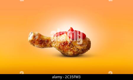 Pollo cotto gamba ketchup salsa spezie isolato su sfondo arancione Foto Stock