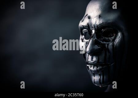 Scary figura con creepy sanguinosa maschera nel buio Foto Stock