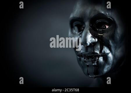 Scary figura con creepy sanguinosa maschera nel buio Foto Stock