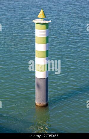 Verde e bianco pilastro di navigazione nel fiume Foto Stock