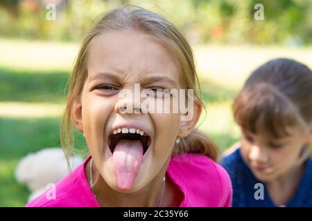 La ragazza si voltò e spettacoli divertenti una lunga lingua Foto Stock