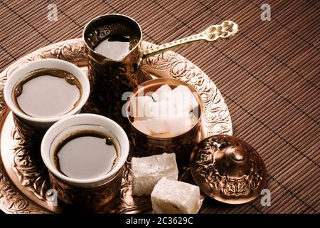 Set tradizionale di caffè turco con due tazze di caffè, zucchero e delizia turca su sfondo marrone. Foto Stock
