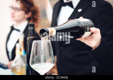 Esperienza di degustazione con un sommelier che serve un bicchiere di Moscato d'Asti (Moscato) spumante ad Alba (Piemonte, Italia) Foto Stock