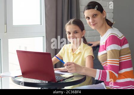 La ragazza e la madre subiscono l'istruzione in linea interattiva nel paese Foto Stock