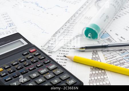 Calcolatrice e matita su carta con la finanziaria del grafico Foto Stock
