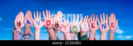 Kids Hands Holding colorful tedesco Word igiene delle mani significa igiene delle mani. Cielo blu come sfondo Foto Stock