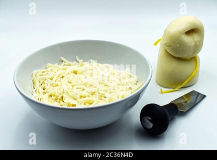 Scamorza, formaggio italiano, con coltello, isolato su fondo bianco Foto Stock