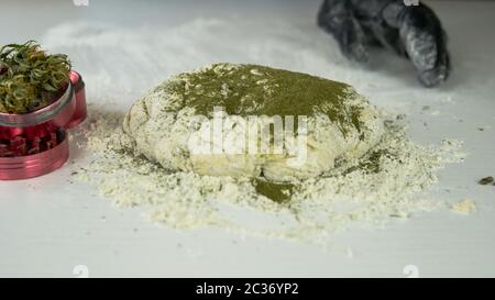 Preparazione per la cottura di canapa o torta di pane. Close-up di pasta fresca con la farina di cannabis. Concetto di utilizza la marijuana in una industria alimentare Foto Stock