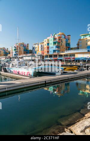 Edifici colorati e barche nel porto turistico di Albufeira, Algarve, Portogallo Foto Stock