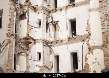 Vecchio edificio demolito a più piani con mattoni e infissi. Demolizione, ristrutturazione, sisma Foto Stock