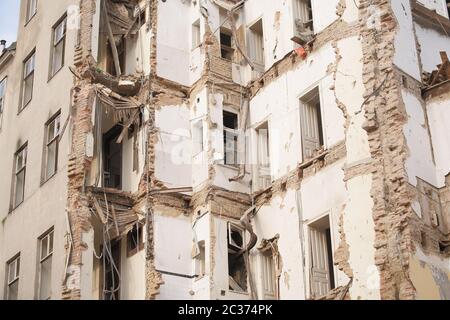 Vecchio edificio demolito a più piani con mattoni e infissi. Demolizione, ristrutturazione, sisma Foto Stock
