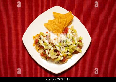 PATATE MESSICANE CON PATATINE DI MAIS, MAIS CARRINATO, CONDITO CON LATTUGA, PANNA ACIDA E SALSA Foto Stock