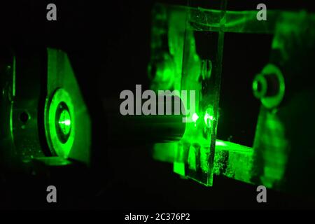 Luce verde in laboratorio. Laser verde al buio. Foto Stock