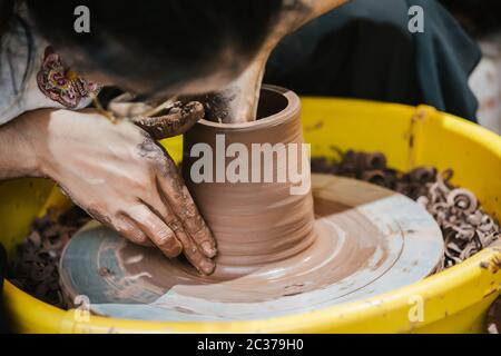 Chongqing, Cina - Agosto 2019 : lavoratore femminile seduto in un laboratorio di produzione ceramica ceramica per la vendita, ci Qi Kou città vecchia Foto Stock