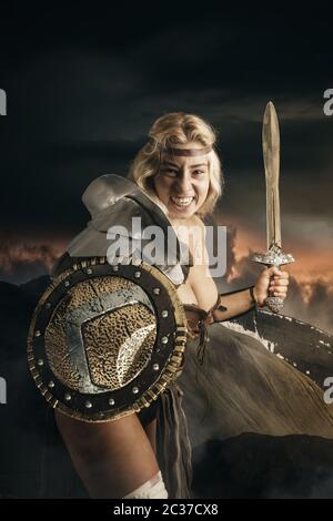 Antica donna guerriero o Gladiator in posa all'aperto con spada e scudo Foto Stock