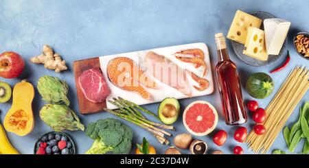 Panorama gastronomico. Carne di manzo, pesce di salmone, pollo e gamberetti, verdure e frutta, vino, pasta e formaggio, sparato dall'alto con Foto Stock