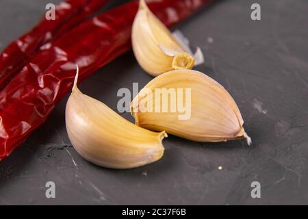 Peperoncini rossi caldi e aglio, isolati su nero. Foto Stock