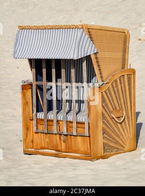 Una sedia da spiaggia chiusa si trova solo sulla spiaggia del Mar Baltico Foto Stock