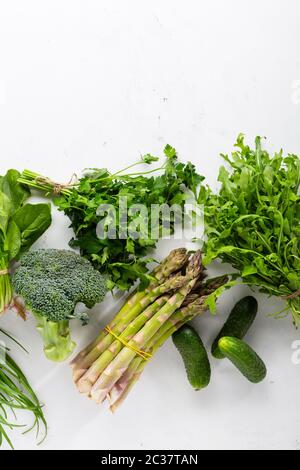 Verdure verdi adagiato su una superficie bianca Foto Stock