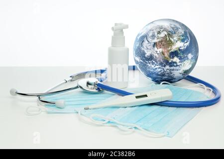 COVID-19. Globo mondiale con stetoscopio, maschere mediche, disinfettante, termometro su sfondo bianco. Quarantena globale, prevenzione delle infezioni, coronaviru Foto Stock