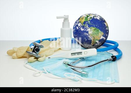 COVID-19. Globo mondiale con stetoscopio, maschere mediche, disinfettante, termometro su sfondo bianco. Quarantena globale, prevenzione delle infezioni, coronaviru Foto Stock