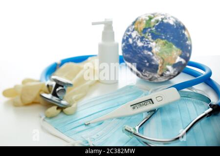 COVID-19. Globo mondiale con stetoscopio, maschere mediche, disinfettante, termometro su sfondo bianco. Quarantena globale, coronavirus. Elementi di questo io Foto Stock