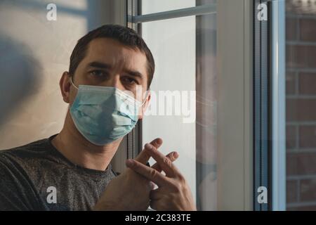 Carcere a casa. Sanzioni autoisolate. Isolamento a casa per l'auto quarantena. Inibizioni sociali durante il Coronavirus. Isolamento forzato della casa. Uomo Foto Stock