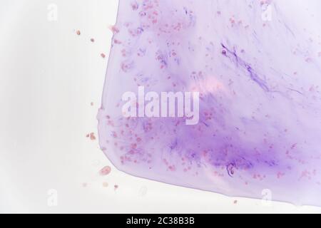 Le macchie blu del colorante nella vasca bianca si sciogliono in acqua. Foto Stock