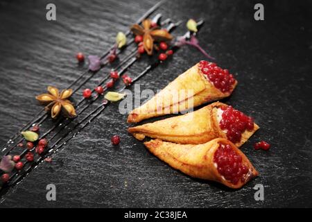 Pate di coniglio in corni croccanti decorato con spezie su un piatto di pietra nera Foto Stock