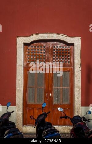 Scooter parcheggiati di fronte a casa in cotto dipinto, Valladolid, Yucatan, Messico Foto Stock