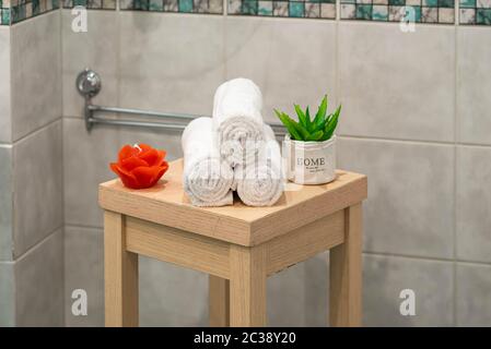 Composizione Spa. Asciugamani bianchi laminati. Candela a forma di rosa.  Fiore verde. Primo piano Foto stock - Alamy