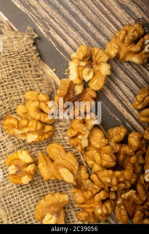 Noci pelate sfuse su un tavolo di legno coperto di tela ruvida. Dieta sana. Dieta di idoneità. Primo piano Foto Stock