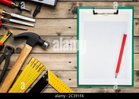 Vista superiore per il falegname e strumenti di notebook per le note su un antico tavolo in legno. Industria edile, fai da te. In legno tavolo di lavoro. Foto Stock