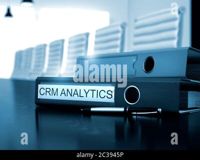 Binder con iscrizione CRM Analytics su legno desktop. CRM Analytics - cartella su tavola di legno. 3D. Foto Stock