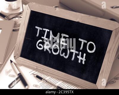 Time to Growth scritto a mano da White Chalk su una lavagna. Composizione con lavagna piccola sullo sfondo del tavolo di lavoro con cartelle di ufficio, Stati Foto Stock