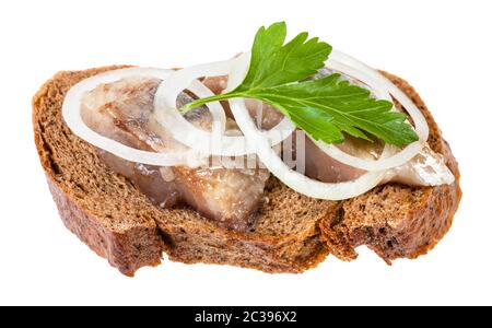 Aprire il panino con pane di segale e aringhe in salamoia decorate di anelli di cipolla e fresco verde foglia di prezzemolo isolati su sfondo bianco Foto Stock