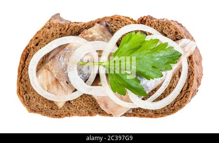 Vista superiore del sandwich aperto con pane di segale e aringhe in salamoia decorate di anelli di cipolla e fresco verde foglia di prezzemolo isolati su sfondo bianco Foto Stock