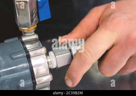 Installazione della gru su un serbatoio con liquido. Adattatori per valvole a sfera e tubi. Foto Stock