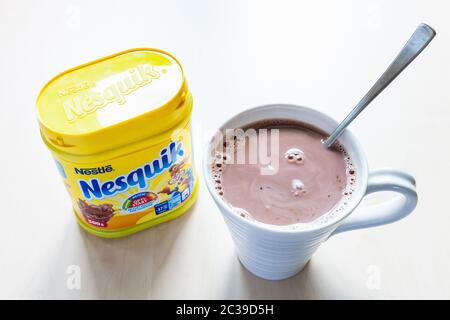 MOSCA, RUSSIA - 16 GIUGNO 2020: Vista dall'alto del vaso chiuso di Nesquik e della tazza con cioccolata calda sul tavolo. La polvere di cioccolato Nesquik è stata introdotta nel 1948 Foto Stock