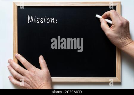Una lavagna con scritto la parola missione Foto Stock