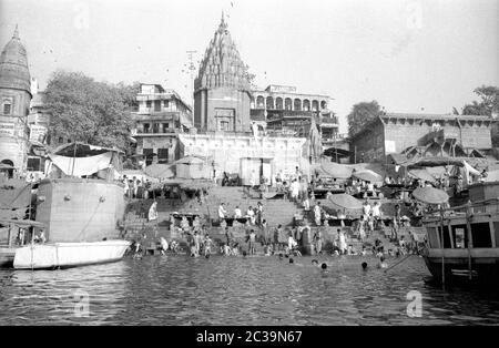 Gli indù si bagnano nel Gange santo nella città indiana di Benares, anche conosciuta come Varanasi o Kashi. Secondo la leggenda, la città vecchia di oltre 2500 anni è la città di Shiva, una delle principali divinità indù. Gli indù credono che il popolo da qui possa spezzare il ciclo eterno delle rinascite e raggiungere la salvezza, così tanti credenti vengono a Benares per morire qui. Foto Stock