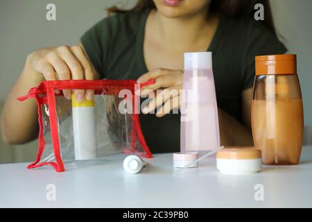 La donna la preparazione di kit da viaggio per il trasporto di prodotti cosmetici su aereo Foto Stock