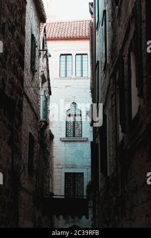 Uno dei molti vecchi edifici all'interno del palazzo diocleziano a Spalato, croazia. Alto e alto incorniciato tra due vecchi edifici con finestre di stile romano. Girato Foto Stock